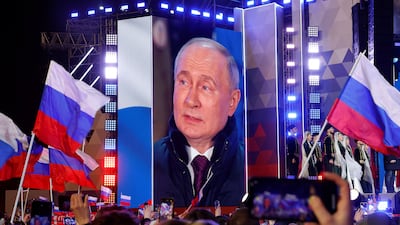 Mr Putin is seen on a big screen at the concert, which took place on Red Square in Moscow on Monday. Reuters