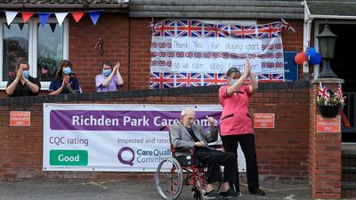 Care home resident Albert Rose, 98, looks on as carers and staff applaud him outside Richden Park care home in Scunthorpe. There was an appeal for people to come forward and help the resident celebrate his birthday, after his only surviving relative was not able to visit due to the pandemic. AFP