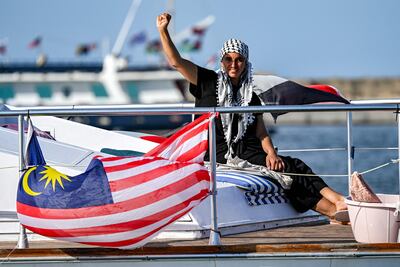 A woman gestures as she rides aboard a vessel with other activists in Bizerte. AFP