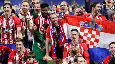Atletico Madrid celebrate with the trophy after winning the Europa League. Gonzalo Fuentes / Reuters