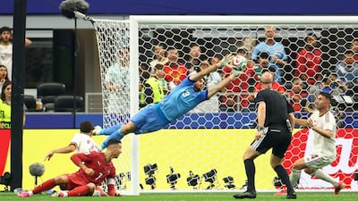 Spain goalkeeper Unai Simon saves a shot from Portugal's Cristiano Ronaldo. Reuters