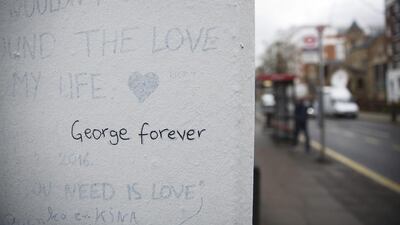 The words "George forever" are seen written on a wall outside Abbey Road studios where the Beatles recorded albums and where the zebra crossing cover picture of the Abbey Road album was originally taken in London. Matt Dunham / AP