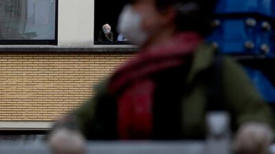 Eve Putseys rides on a crane platform to visit her deaf aunt Suzanne Putseys, waiting in her upper story window at the La Cambre senior living home in Watermael-Boitsfort, Belgium. AP