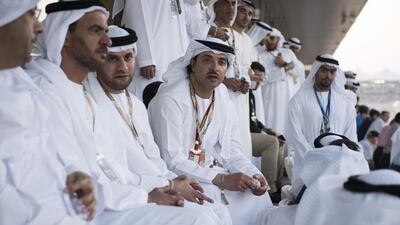 Sheikh Hazza bin Zayed, National Security Advisor and Vice Chairman of the Abu Dhabi Executive Council, fourth left, Dr Ahmed Mubarak Al Mazrouei, Chairman of the Abu Dhabi Water and Electricity Authority and Secretary-General of the Executive Council, third left, and Nasser Ahmed Al Sowaidi, Chairman of the Energy Authority and Executive Council Member, second left, watch the final of the 2014 Formula 1 Etihad Airways Abu Dhabi Grand Prix at Yas Marina Circuit. Rashed Al Mansoori / Crown Prince Court — Abu Dhabi