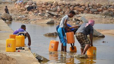 Yemeni men fill plastic jerrycans with water in the south-eastern city of Al Mukala on November 6, 2015. STR/AFP Photo