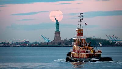 May's full Moon, known as the Full Flower Moon and the last supermoon of the year, sets behind the Statue of Liberty. AFP