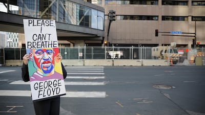 An activist holds a sign outside the Hennepin County Government Center in Minneapolis, Minnesota, during the trial of former police officer Derek Chauvin. Reuters
