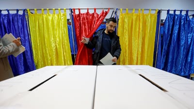A Romanian man exits the voting booth after stamping his ballot during the parliamentary elections at Cezar Bolliac Primary School polling station in Bucharest, Romania. EPA