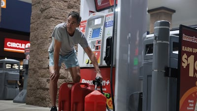 A Florida resident fills containers with petrol as he prepares for Hurricane Isaias to make landfall on the US Gulf coast. Getty Images