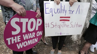 People hold signs during a rally. Jonathan Alcorn / AFP