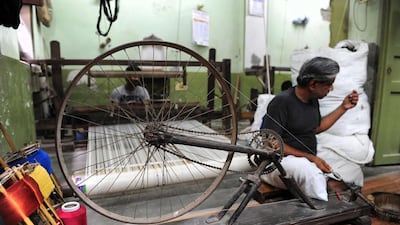 A worker prepares silk threads before weaving Banarasi saris inside a handloom factory in Rajapura Varanasi. (Sanjay Kanojia / AFP Photo / April 22, 2014)