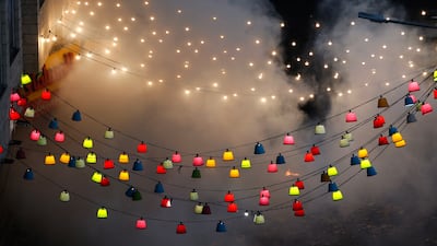 Smoke rises above coloured lanterns. EPA