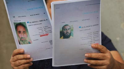 An Iraqi man holds printed profiles of Abu Bakr Al Baghdadi and his deputy Abd Al Rahman Al Qaduli released by Iraq authorities on February 6, 2018. AFP