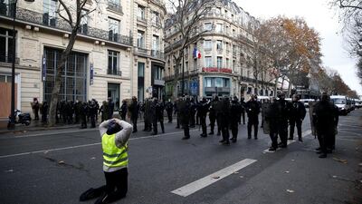 A protester wearing a yellow vest faces off with French CRS riot police during a national day of protest by the 'yellow vests' movement in Paris. Reuters