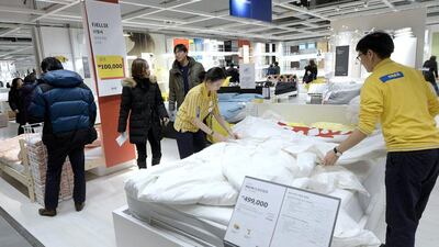 Employees work on a display as visitors browse through products at the Ikea store in Gwangmyeong. Ahn Eun-na / News1 / Reuters