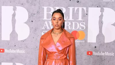 Grace Carter in a sheeny orange mac, which she actually makes super cool. Photo: Getty