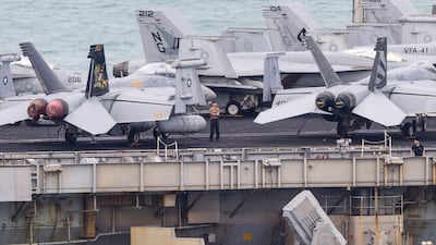 A crew member stands on the flight deck of the nuclear-powered aircraft carrier USS Abraham Lincoln as it heads towards the port of Laem Chabang, Thailand. AFP