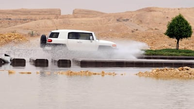 A car drives through a flooded street in northern Riyadh after heavy rains cause floods and traffic jams. Fayez Nureldine / AFP
