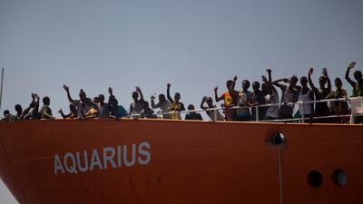 Migrants wave from SOS Mediterranee Aquarius rescue ship, after being rescued by members of the Spanish NGO Proactiva Open Arms during an operation at the Mediterranean sea. AP