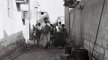 Drummer Khamees, an Abu Tabla, walks the alleyways of Abu Dhabi with his entourage to wake people for the day’s fasting in the 1970s. Photo: Al Itihad