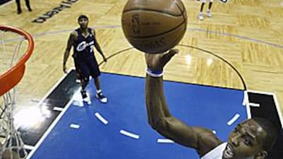 Orlando Magic's Dwight Howard, right, goes to the basket against the Cleveland Cavaliers during the first half.