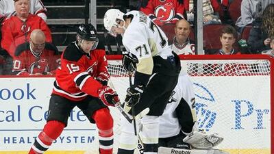 New Jersey's Travis Zajac looks for a way past Pittsburgh's Evgeni Malkin.