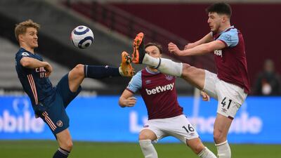 Arsenal's midfielder Martin Odegaard and West Ham United's midfielder Declan Rice fight for the ball. AFP