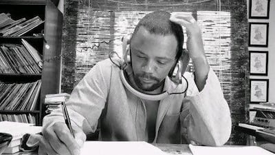 Composer Quincy Jones at his home studio in October 1974 writing music, listening to a recording on his headphones.