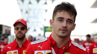 Leclerc is followed by his teammate Sebastian Vettel as they walk through the pit lane on Saturday. AP