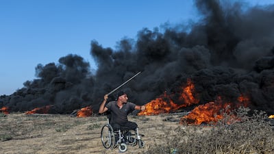 A Palestinian protester throws stones at Israeli troops during clashes on Friday. EPA