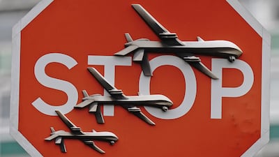 The artwork features three drones on a traffic Stop sign