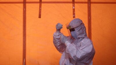 A healthcare worker holds a swab sample for the Covid-19 antigen test in Yogyakarta, Indonesia. Reuters