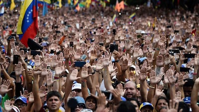 People raise their hands during a mass opposition rally against President Nicolas Maduro in Caracas last week. Federico Parra / AFP