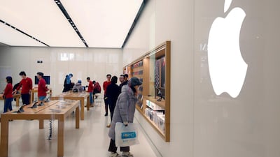 A customer looks at Apple products on display in a shop in Beijing. EPA