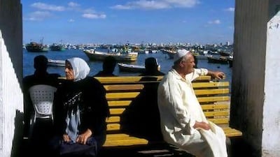 Locals wait at a bus stop along Alexandria's seafront promenade. The city boasts a 32-kilometre-long coastline. Getty Images