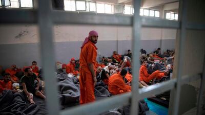 Men, allegedly affiliated with the ISIS, sit on the floor in a Kurdish prison in the north-east Syrian. AFP