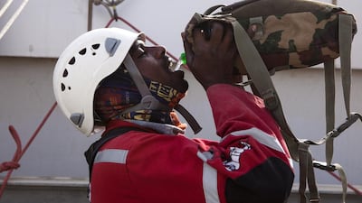 A worker hydrates himself before beginning his descent of the Gate Tower Reem Island. Christopher Pike / The National