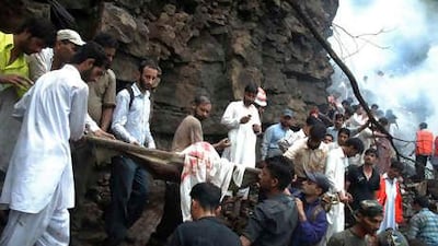 Rescue workers and volunteers recover the body of a victim from the passenger plane which crashed in Islamabad's Margalla Hills, killing 152 people, the worst aviation accident in Pakistan.