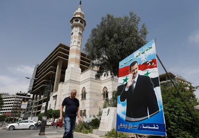 A man walks past a poster of Syrian President Bashar Al Assad ahead of this month's presidential election, in Damascus on May 3. AFP