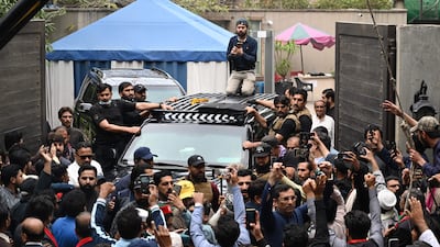 Supporters of former Pakistan's Prime Minister Imran Khan gather around his car as he leaves his residence in Lahore, on his way to appear in a court in Islamabad. AFP