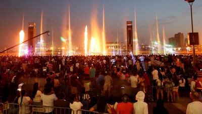 People from many nationalities and religions watch a laser and light show at Dubai Festival City on the second day of Eid Al Fitr.