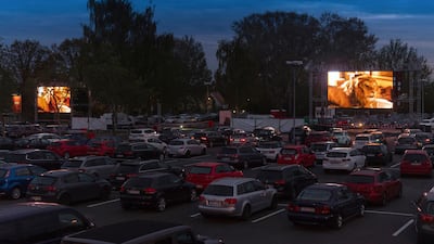 Numerous cars are parked in front of screens at a drive-in cinema for the film 'Jumanji' in Dresden, Saxony, Germany. dpa via AP