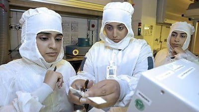 The UAE university student Khawla Al Maysari works on a project with Hamda Al Shehhi, left, and Alia Al Dhaheri, right, during their seven-week semiconductor internship programme at GlobalFoundries in Dresden, Germany. Jeff Topping / The National