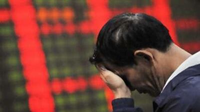 Oh dear. A Chinese investor stands dejectedly in front of a price board at a private security firm in Shanghai.