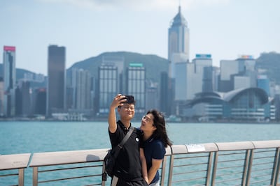 Tourists pose for photos on the Tsim Sha Tsui waterfront in Hong Kong, China. EPA