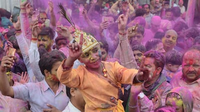An Indian boy dressed as Lord Krishna dances along with devotees covered with coloured powder during Holi celebrations in Amritsar. Narinder Nanu / AFP Photo