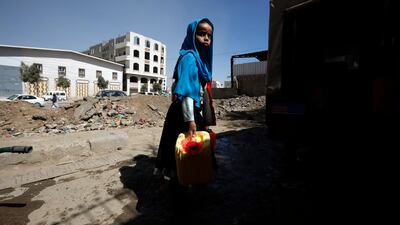 A Yemeni child holding empty plastic bottles waits to collect clean water from a charity water tap in Sana'a, Yemen. EPA