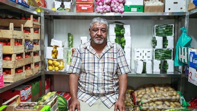 Mohammed Rafai, a Syrian produce merchant at the Mina Zayed fruit and vegetable market, sits inside one of his refrigerators. He estimates he lost Dh3,000 in produce due to electricity restrictions this month, the equivalent to about a third of his monthly profit. Victor Besa / The National