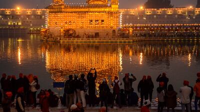 Sikh devotees pay respect on the occasion of the birth anniversary of the 10th Sikh Guru Gobind Singh, at the illuminated Golden Temple in Amritsar. AFP