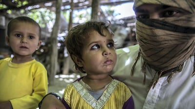 Qary Khalid, an Afghan Taliban commander, with his children Fahim, three, and Narges, two. Stefanie Glinski for The National